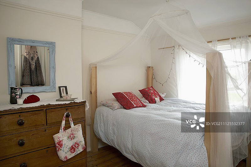 乡村风格卧室，带旧抽屉柜和蚊帐双人床图片素材