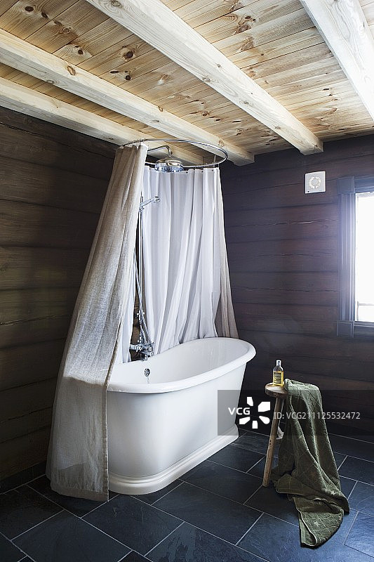 乡村现代浴室一角的复古浴缸与浴帘，灰色瓷砖地板图片素材