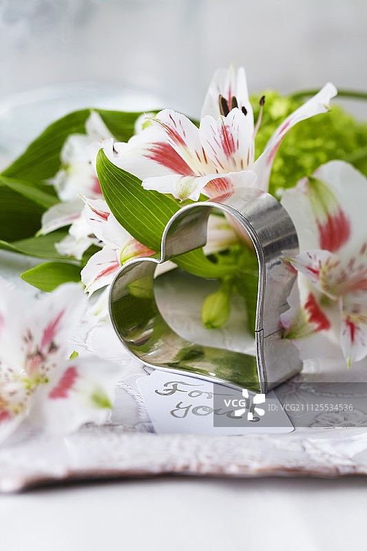 用心形糕点切割器、座右铭和百合花装饰的盘子图片素材