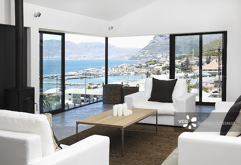 可欣赏山地海岸线全景的室内设计 - 木质桌面咖啡桌和白色沙发组合图片素材