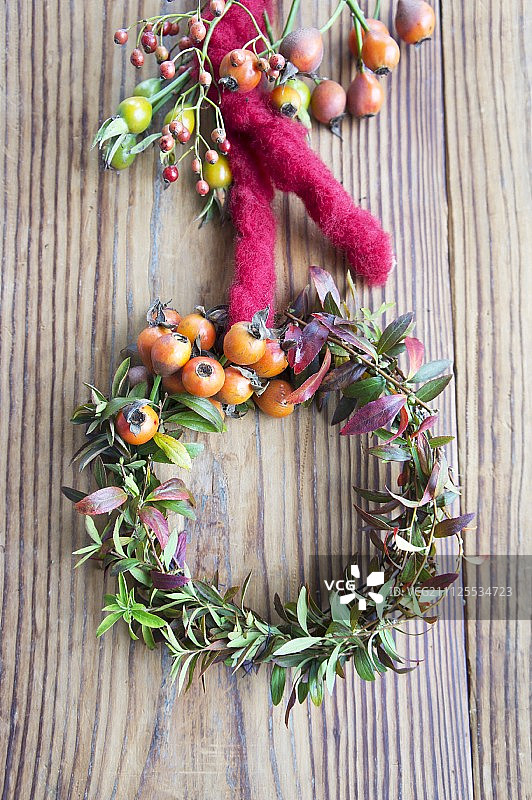 婚礼招待会桌子上绣线菊枝条和玫瑰果花环图片素材