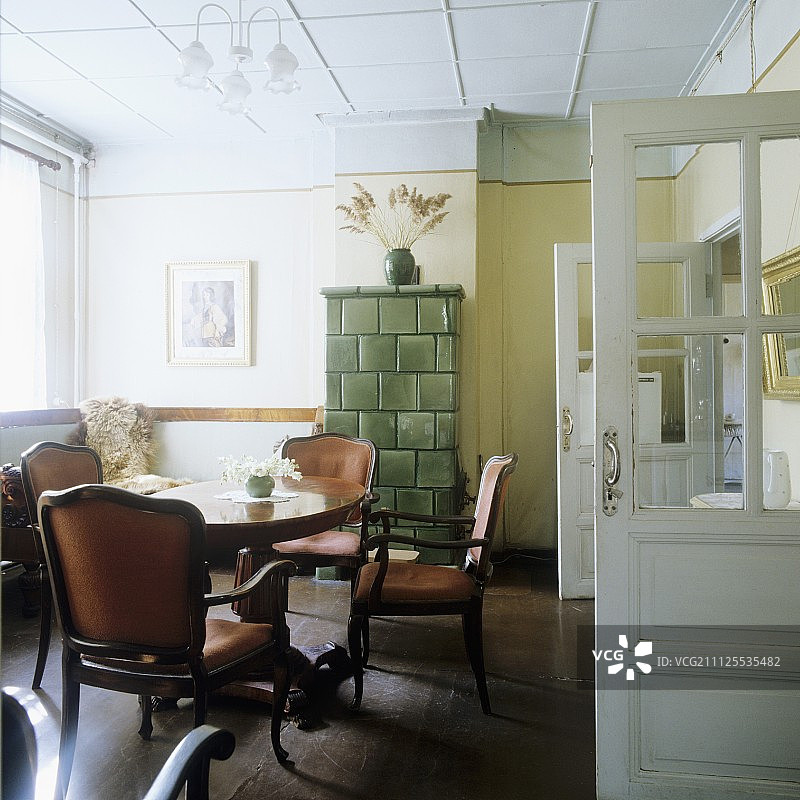 乡村风格房间内的古董扶手椅和瓷砖炉图片素材