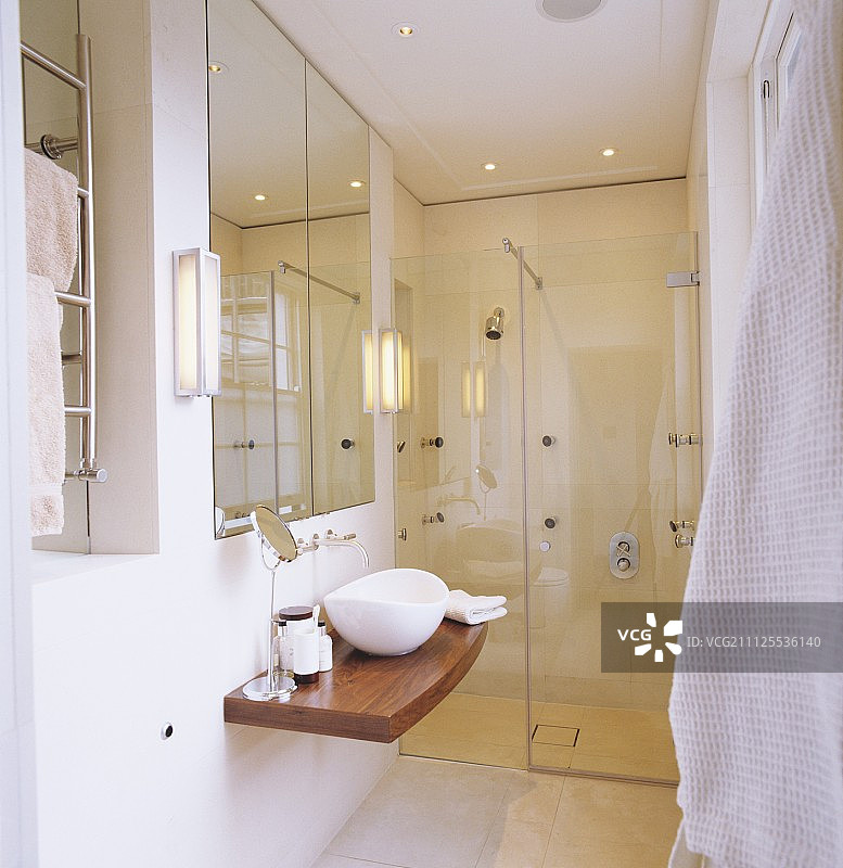 设计师浴室：木质台面上的小型水槽，玻璃淋浴区图片素材