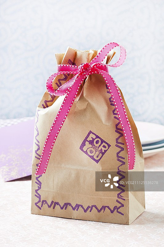 带有丝带和手工橡胶印章图案的纸质礼品袋图片素材