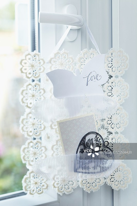 手工制作的便笺架由钩针花边和蕾丝带制成挂在门把手上图片素材