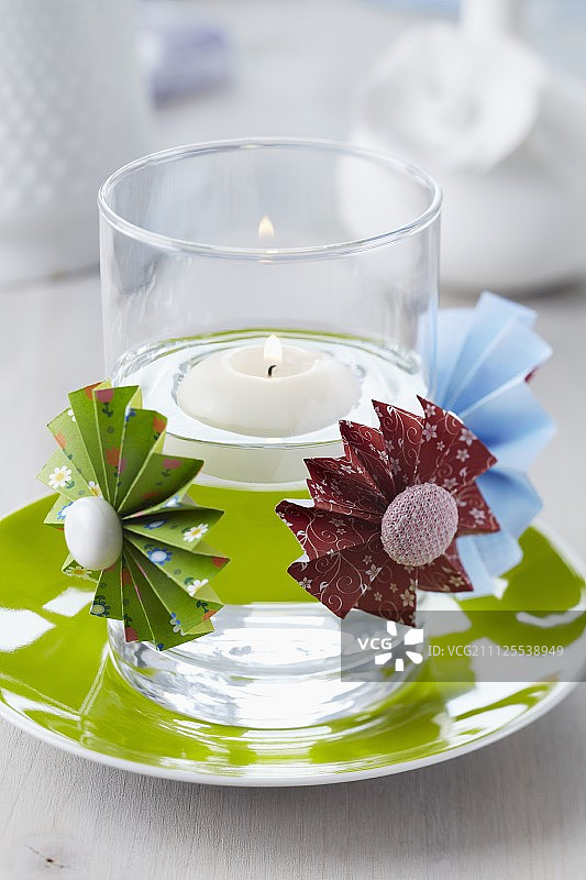 用纽扣装饰中心的彩色纸花，装饰着漂浮灯笼的蜡烛灯笼图片素材