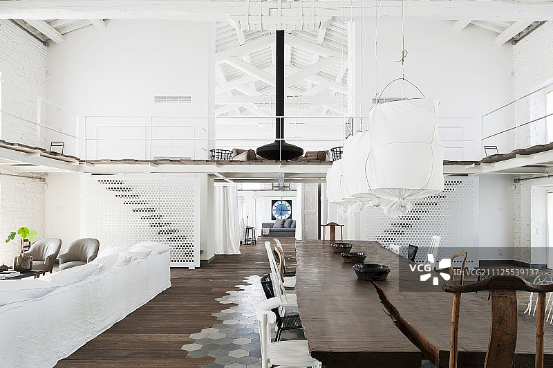 阁楼公寓休息区：吊灯下的乡村风格实木桌子，搭配白色织物灯罩图片素材