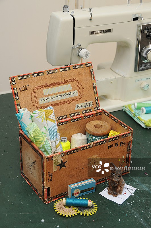 用印花和纸胶带装饰的再生雪茄盒，用作缝纫盒，内含织物边角料和线轴图片素材