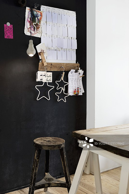 黑色钉板前的复古凳子和旧木桌图片素材