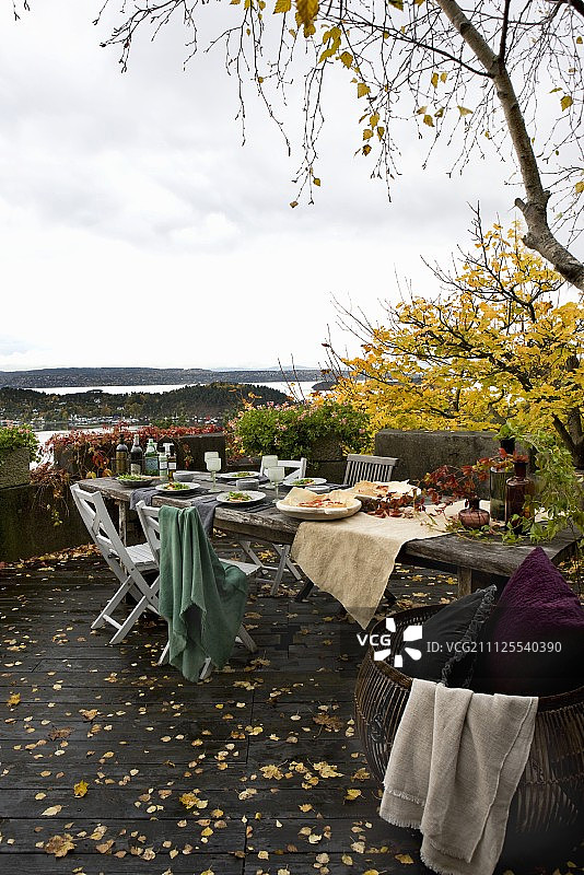 带有乡村餐桌的秋季露台，可欣赏挪威礁海岸的景色图片素材