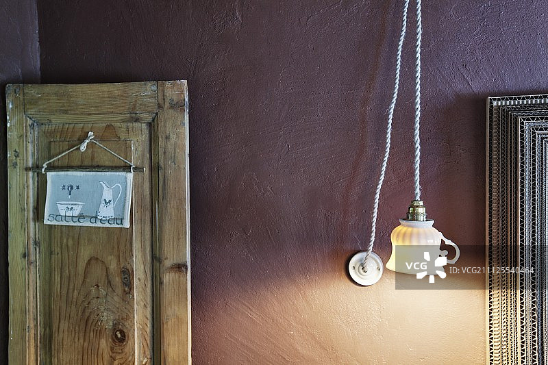 用旧茶杯改造的吊灯，背景为淡紫色墙壁；标志悬挂在乡村木板上图片素材