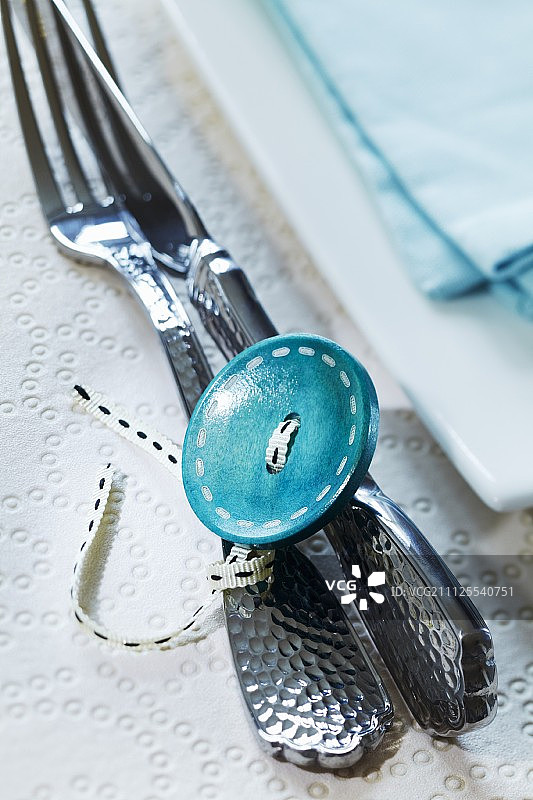 用丝带和大纽扣系在一起的餐具图片素材