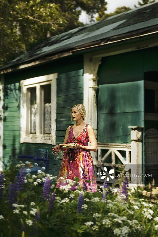 在瑞典，木屋外的金发女人图片素材