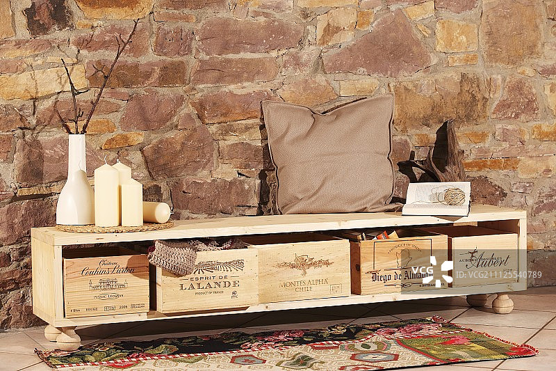 DIY餐具柜，用葡萄酒箱作储物箱，靠石墙放置图片素材