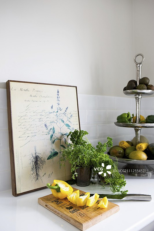 木制砧板上切开的黄色甜椒，前面是欧芹和蔬菜蛋糕架，老式植物图谱图片素材