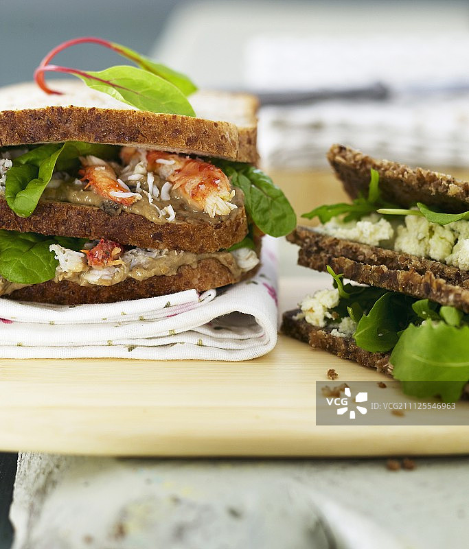 搭配布尔辛奶酪、芝麻菜、蟹肉和茄子鱼子酱的深色面包三明治图片素材