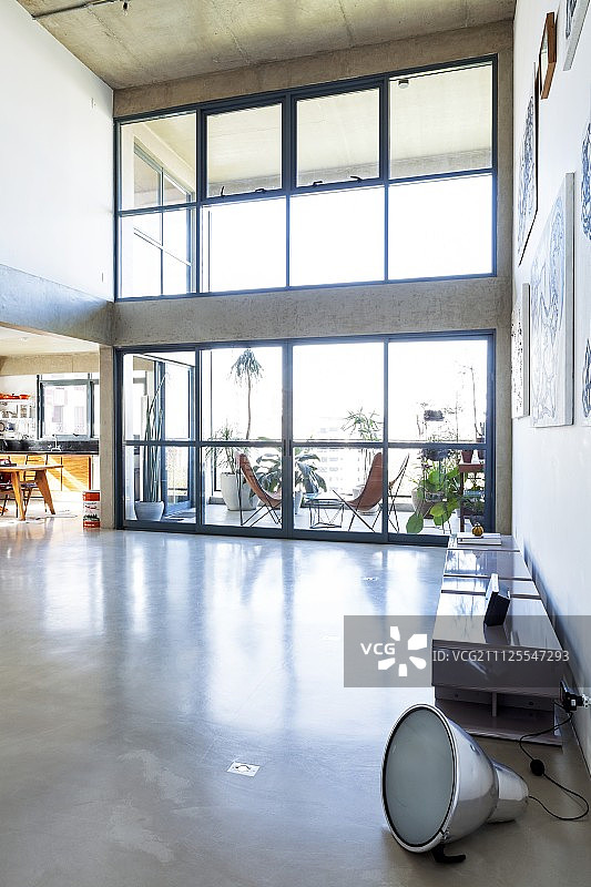 带有高玻璃墙和带家具露台景色的阁楼风格室内设计图片素材