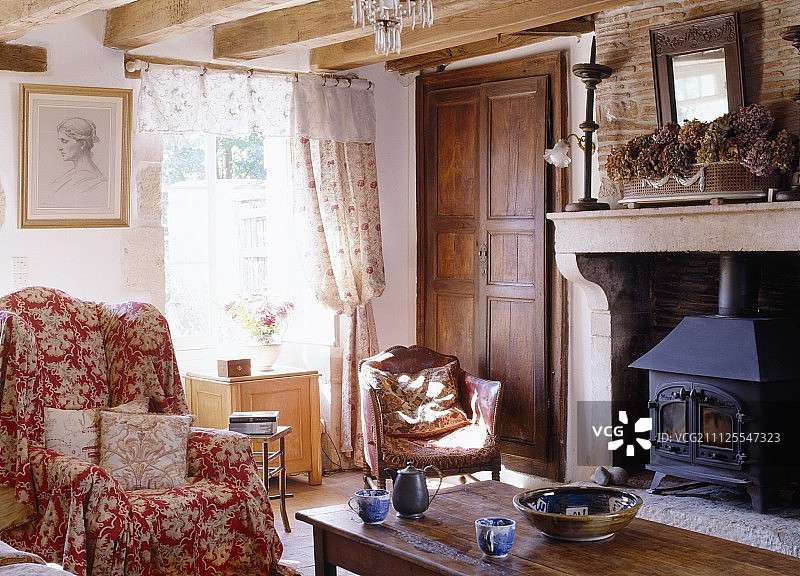 在法国农舍明亮的窗户前，带有松套和手工散垫的靠背椅图片素材