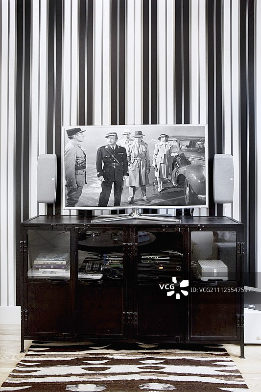 带平板电视的黑色矮柜和黑白条纹壁纸图片素材