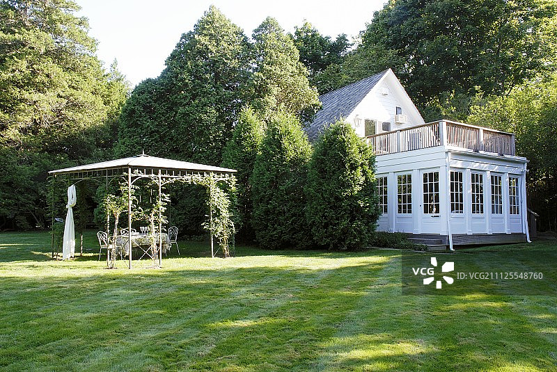 大型花园中凉棚和带屋顶露台的粉刷房屋图片素材