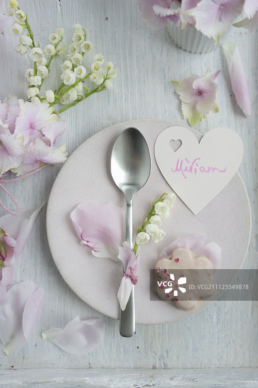 心形名牌、玫瑰花瓣饼干和装饰有铃兰的勺子图片素材
