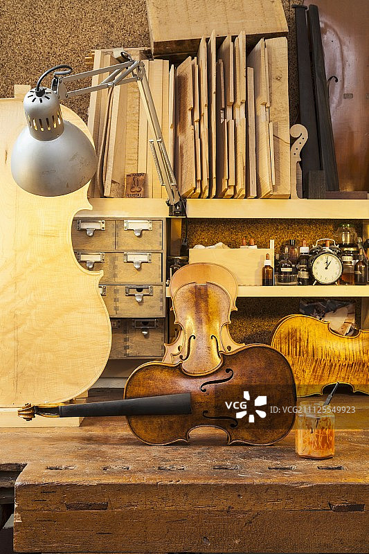 乡村工作台上未上弦的小提琴和其他弦乐器图片素材