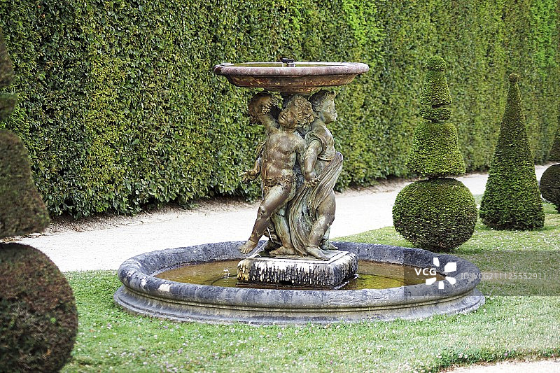 凡尔赛宫的石雕喷泉和黄杨树图片素材