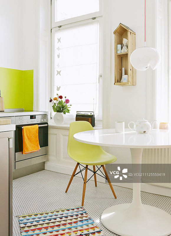 厨房中的经典家具组合：白色厨房中的郁金香桌和绿色贝壳椅图片素材
