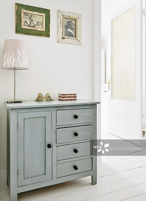 门厅内，乡村风格的浅灰色橱柜上的台灯图片素材