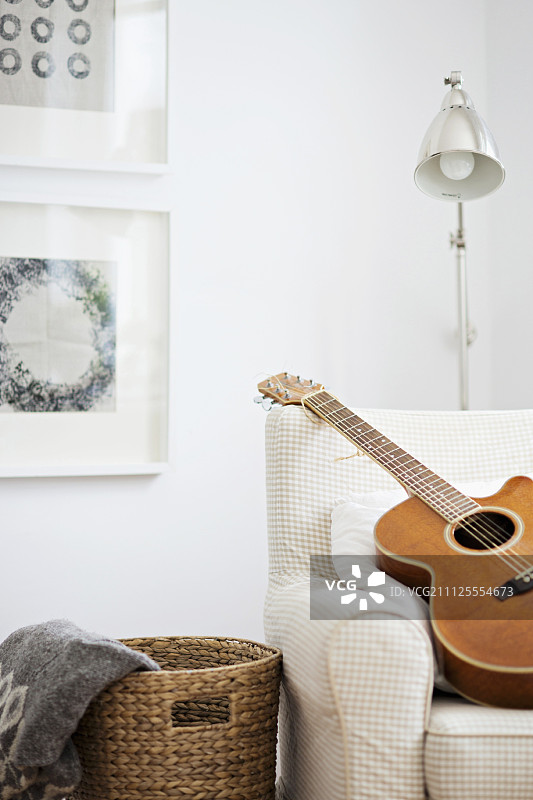 扶手椅上的吉他，角落里的复古落地灯图片素材