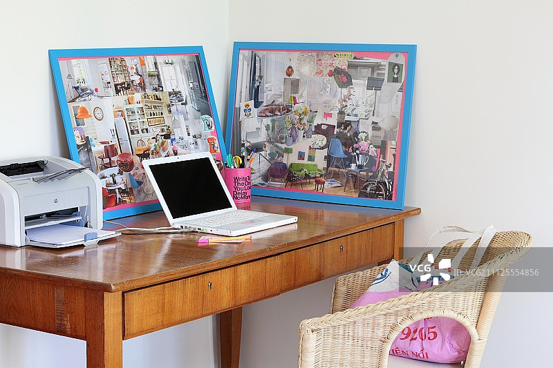 精致的五十年代风格写字台上的笔记本电脑、打印机和带框拼贴画图片素材