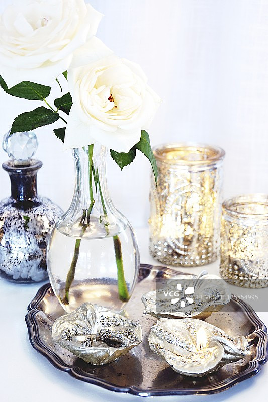 银色托盘上的叶形餐具和白色玫瑰花瓶图片素材
