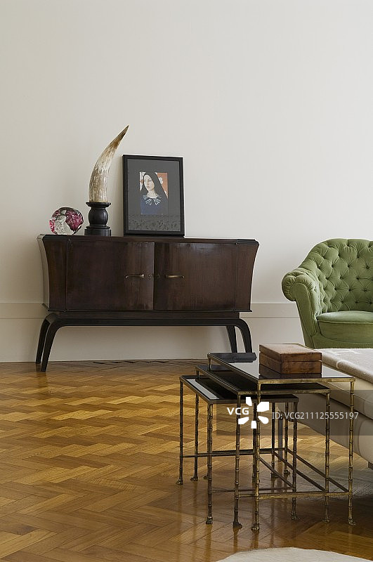 简约复古风客厅家具：餐具柜和人字形拼花地板上的边桌图片素材