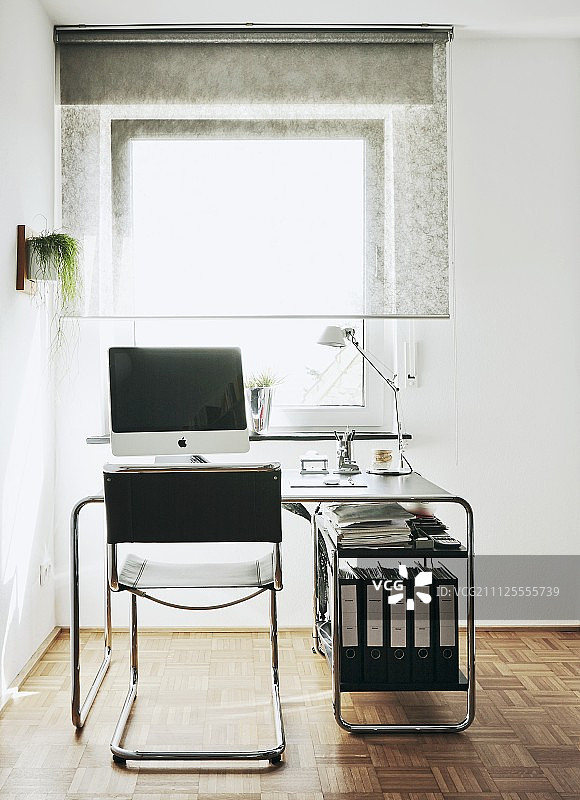 皮革座椅悬臂椅与半透明卷帘前的经典书桌图片素材