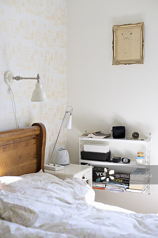 木床、床头柜、白色细绳架和金色画框中的儿童画图片素材