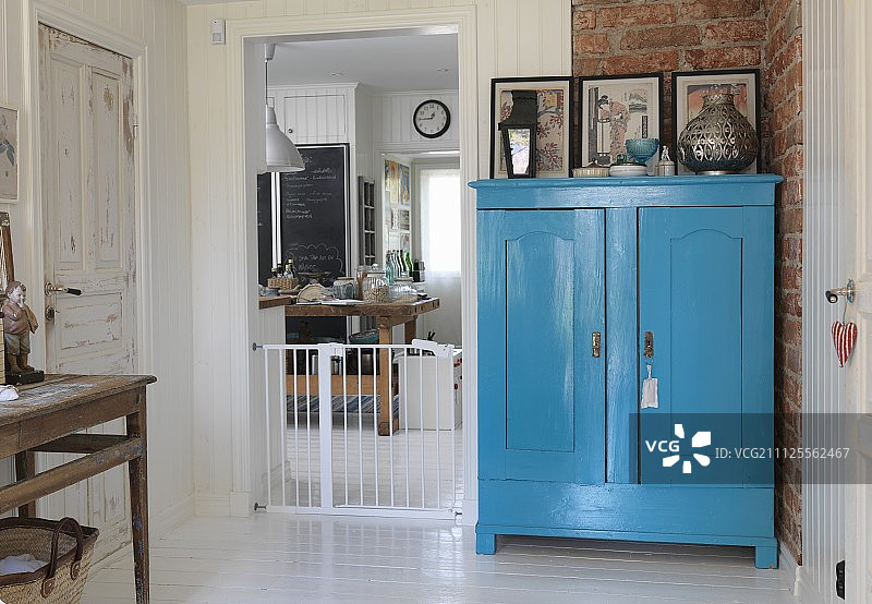 厨房门口砖墙旁的蓝色农舍碗柜图片素材