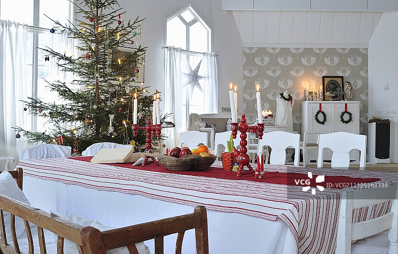 圣诞树前餐桌上的红白色斯堪的纳维亚装饰图片素材