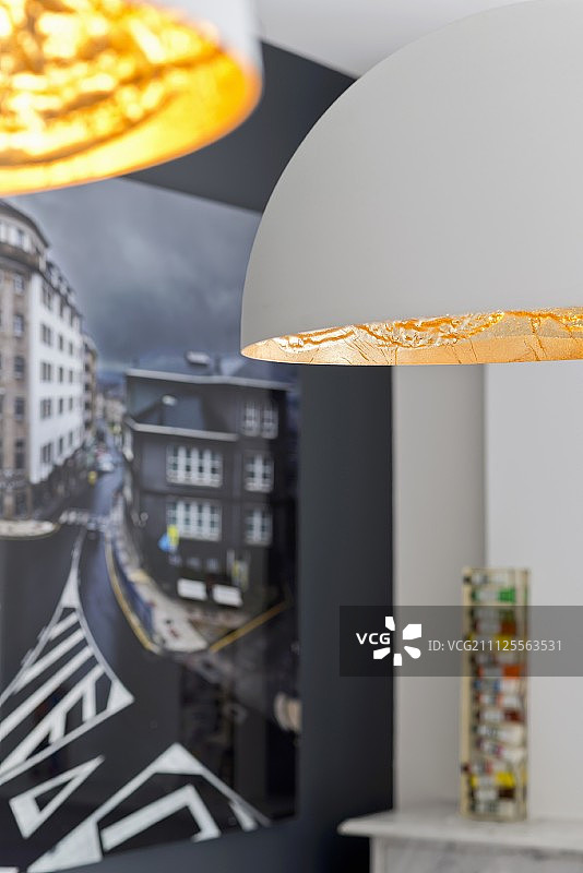 带有白色和金色灯罩的吊灯细节；黑色墙壁上的摄影艺术图片素材