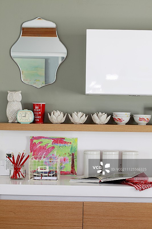 厨房台面，白色工作台面，储物罐，儿童画作，灰色木架上的陶瓷碗图片素材