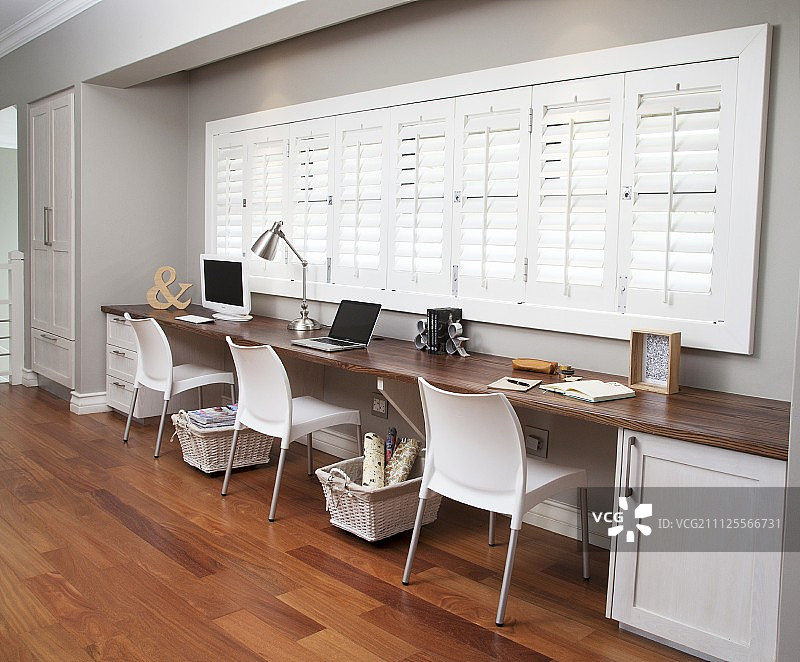 走廊窗户壁龛中的三人办公室；长桌下方的脚轮储物篮图片素材