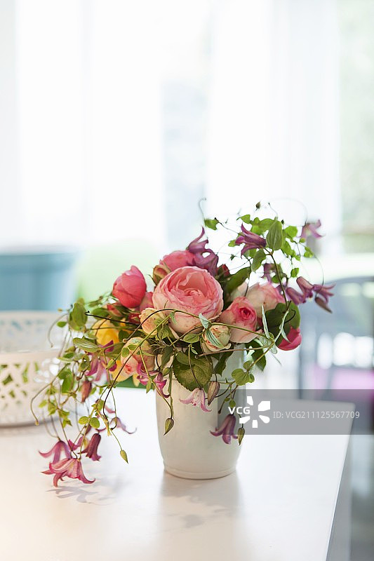 白色花瓶中芬芳的英国玫瑰、铁线莲和其他花朵图片素材