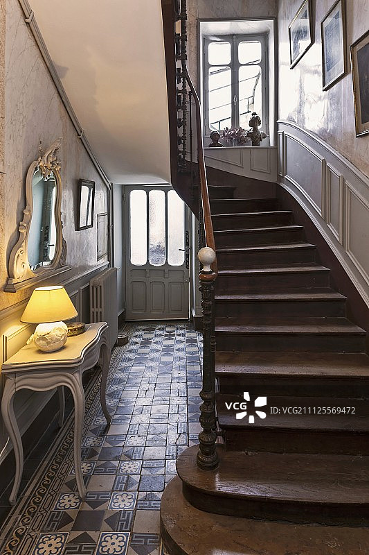历史建筑内的门厅：控制台桌上的台灯和楼梯图片素材