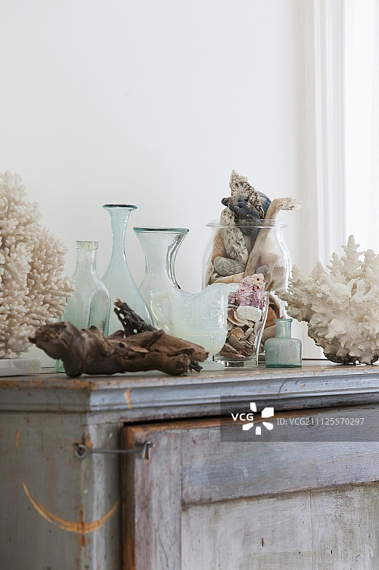 浴室老式橱柜上的花瓶、玻璃容器和漂浮物图片素材