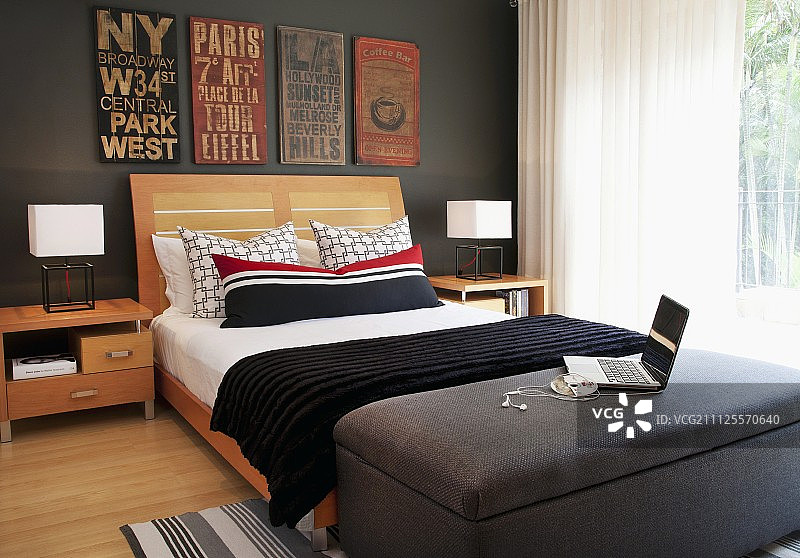 灰色墙壁房间内的木制床头双人床图片素材