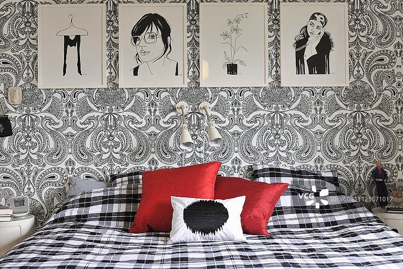 黑白图画卧室：佩斯利花纹墙纸，格子床品，红色靠垫图片素材
