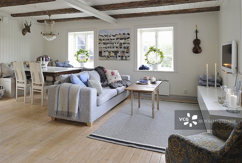 开放式室内，木墙和外露天花板梁的餐厅和带沙发休息区图片素材