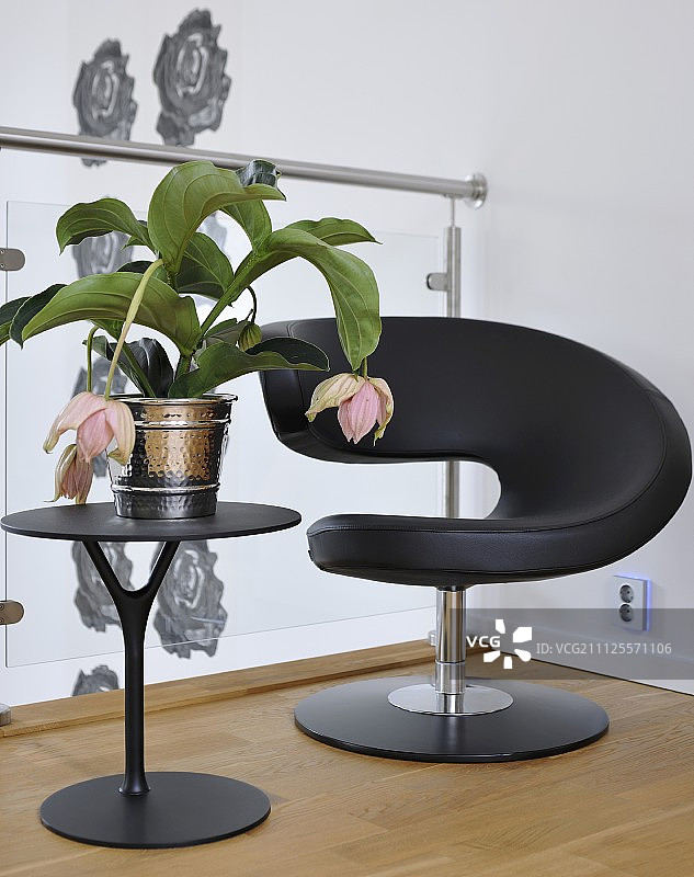 玻璃栏杆前方的黑色设计师休闲椅和边桌图片素材