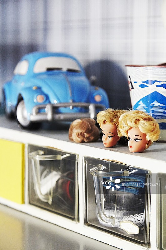 旧柜子上的芭比娃娃头图片素材