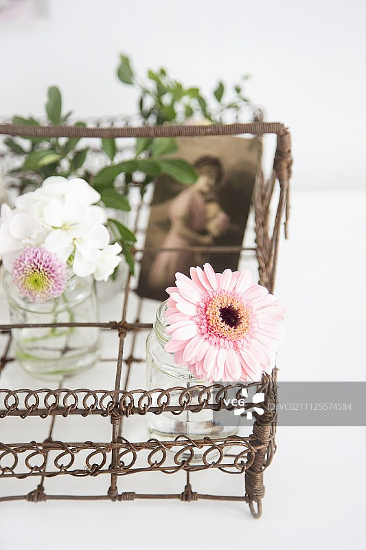 装饰着花瓶和纪念照片的复古金属丝篮图片素材