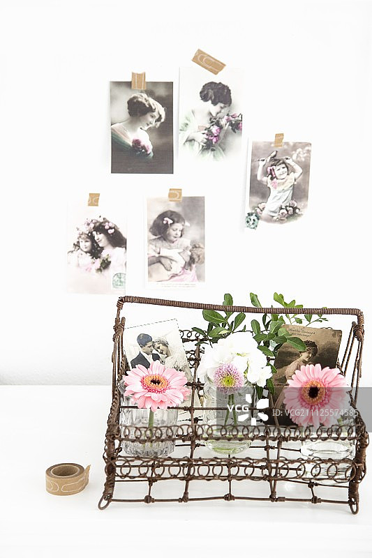 装饰着花瓶和旧家庭照片的复古金属丝篮图片素材